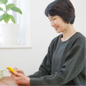 スマートフォンを操作する香川良子さんの写真