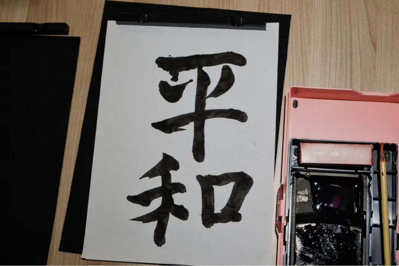 「平和」の書を持った写真